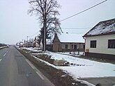 Samatovci during the winter with on a road overlooking a long line of houses covered with snow
