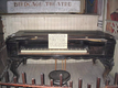 The original 1881 rosewood piano sits before the stage