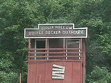 "Booger Hollow Double Decker Outhouse" in August 2007, abandoned and with missing door and signs. Booger Hollow.jpg