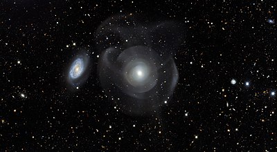 NGC 474's (right) tidal tails and shell-like structures may be from collision(s) with another galaxy. A neighboring spiral galaxy, NGC 470, is on the left. Elliptical galaxy NGC 474.jpg