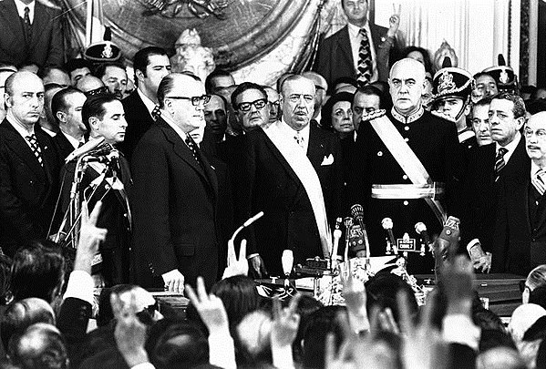 Cámpora takes the oath as President of Argentina in 1973. The then-president of Chile, Salvador Allende, can be seen over Cámpora's right shoulder.