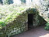 Struktur batu dengan archway, tertutup rumput