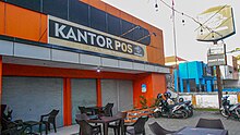Indonesia did not adopt the Dutch language after independence. However the Indonesian language absorbed a lot of Dutch vocabulary into its language. Seen here is the kantor pos (from Dutch postkantoor), meaning post office. Kantor Pos Indonesia cabang Telanaipura - Telanaipura, Kota Jambi, JA (23 April 2021).jpg