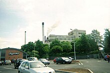 Parking lot, with a factory and a Pizza Hut in the background