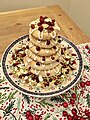 A small kransekake, decorated with nuts and fruit as well as the traditional white glaze