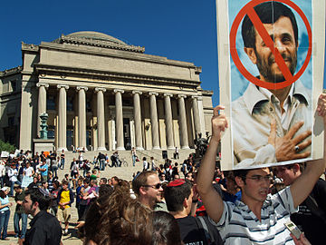 Protesters hold a sign showing Mahmoud Ahmadinejad who spoke at Columbia University on that day.