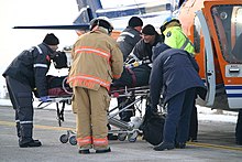 Paramedics load an injured woman into an air ambulance after a head-on collision in the Kawartha Lakes region of Ontario, Canada. Medical evacuation after car accident Kawartha Lakes Ontario.jpg