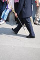 Fotografia di una persona che cammina, portando una spada al braccio sinistro.