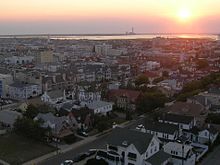 A view over a town early in the morning with a power plant smokestack in the background