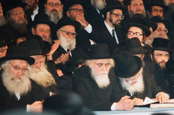 Shach (late 1980s), seated right, looking down at book. Yosef Shalom Eliashiv and Chaim Kanievsky are to his left.