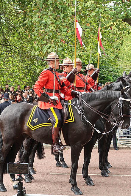 RCMP members, wearing the Red Serge, participate in the funeral procession of Queen Elizabeth II, September 19, 2022.