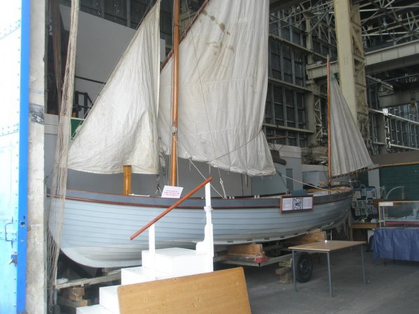 A restored Montagu whaler in Portsmouth dockyard. The mainsail is displayed in a reefed condition: the yard would normally be higher up the mast and the sail coming down lower.