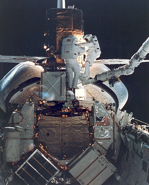 Mission Specialists George Nelson and James van Hoften repair the captured Solar Maximum Mission satellite on April 11, 1984