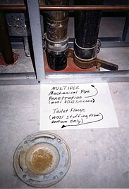 Firestop image showing toilet flange and other mechanical pipe penetrations in a concrete slab.