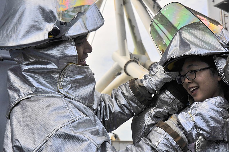 File:US Navy 111001-N-HU253-017 Aviation Boatswain's Mate (Handling) Airman Enrique Montez, from Okinawa, Japan, helps a guest put on firefighting equip.jpg