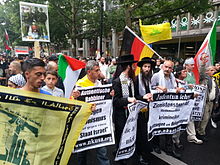 Two Neturei Karta members join in a large anti-Israel demonstration in Berlin, alongside Iranian and Hezbollah flags. Al-Quds 2014 Berlin 20140725 173841.jpg