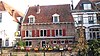 Huis, waarvan vooral de achterzijde, aan Langegracht gelegen, 17e-eeuwse indruk maakt. Afgeknotte puntgevel aan de Krommestraat. Deur met bovenlicht en houten omlijsting. Inwendig: muurschildering van St.Joris