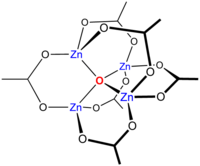 Skeletal chemical formula of a three-dimensional compound, featuring oxygen atom in the center, bonded to four Zn atoms. The latter are interconnected through oxygens and O-C-O groups.