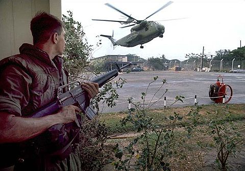 A U.S. Marine provides security as American helicopters land at the DAO compound
