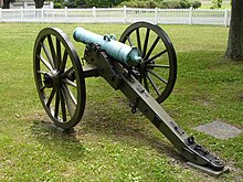 Photo shows an American Civil War era cannon with two handles on top of the barrel.