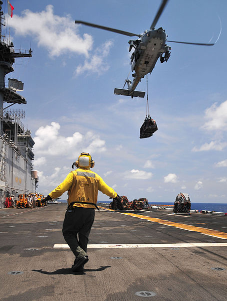 File:Defense.gov News Photo 110519-N-ZS026-132 - U.S. Navy Petty Officer 3rd Class Rodolfo Lopez signals an MH-60 Seahawk helicopter with Helicopter Sea Combat Squadron 23 to lower a pallet of.jpg