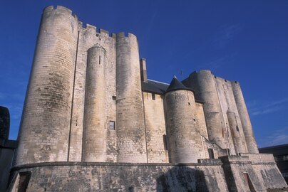 photo couleur d'un château fort. Les tours rectangulaires d'angle sont renforcées de tourelles cylindriques entre lesquelles des contreforts hémicylindriques les renforcent.