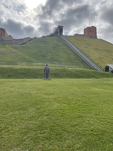 Gediminas tower and castle ruins in Vilnius, and a statue of king Vytautas the Great at the foot of the hill
