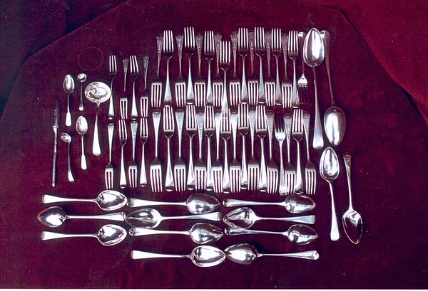 A set (known as a canteen) of Georgian era silver cutlery, including ladles, and serving spoons. The thin item on the left is a marrow scoop for eatin