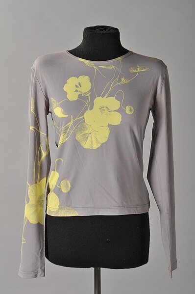 File:Grijs shirt met lange mouw en opdruk lichtgele bloemen op linkermouw en voorzijde links, “Mansharey”, objectnr 79782.JPG