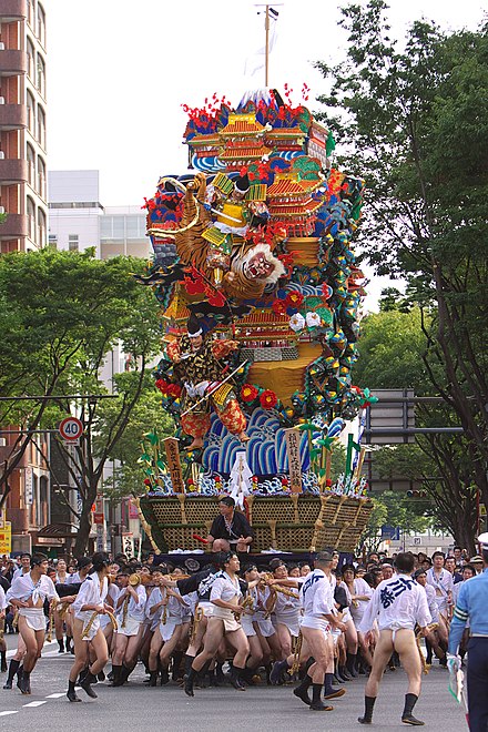 Yamakasa participants carry one of the participating floats