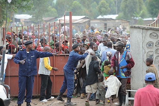 Voedseldistributie door Unicef in Kibati-camp, Goma, Congo, november 2008. Het enorme aantal mensen dat hulp nodig heeft maakt de distributie moeilijk.
