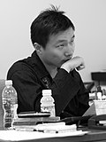 Mustavalkoinen kuva Jenova Chenistä työpöydän edessä