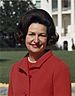 Lady Bird Johnson, photo portrait, standing at rear of White House, color, crop.jpg