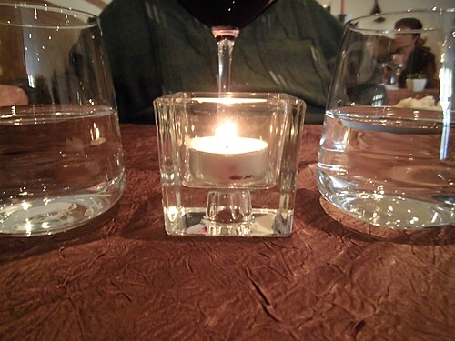 Candle between glasses of water in a French restaurant