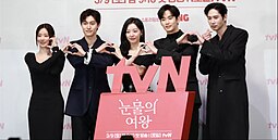 The series' main cast at a press conference doing hand hearts.