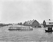 In het water gestrande bus van lijn B van het GVB tijdens de overstroming in Tuindorp Oostzaan; 14 januari 1960.