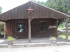 Foto di un edificio rustico in legno.  Il portico è sormontato da una grande stella.