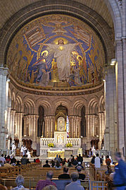 Tras el altar mayor de la basílica del Sacré Cœur se dispone un retablo neorrománico.[204]​