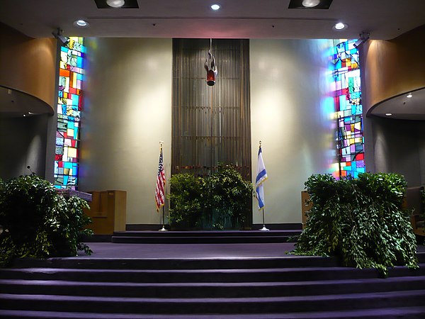 A synagogue sanctuary adorned in greenery in honor of Shavuot