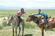 A girl and a boy riding their horses