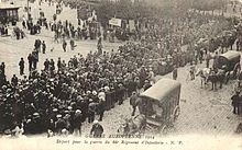 Zwart-witfoto van een colonne marcherende soldaten, omringd door burgers.