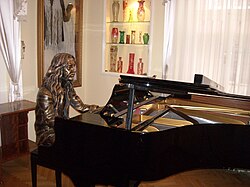 Barış Manço Evi'nde bulunan Barış Manço'nun heykeli ve piyanosu.