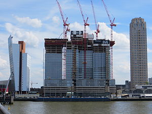 June 2012: De Rotterdam under construction, as seen from the Erasmus Bridge. Left the KPN Tower, right New Orleans. The low rise in front is the Rotterdam Cruise Terminal. De rotterdam in aanbouw juni 2012.JPG