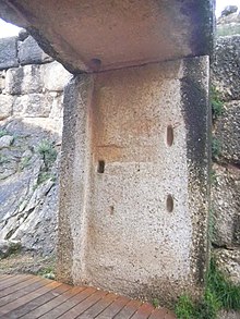 Intérieur d'une porte. La pierre de jambage présente trois orifices.