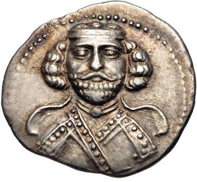Phraates III's portrait on the obverse of a coin, showing him with a beard and a diadem on his head. Minted at Ecbatana in c. 62