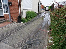 The former site of the Hull Corporation's Wheeler Street trolleybus sheds, photographed from Anlaby Road in Kingston upon Hull. All that largely remains of the sheds are the tracks leading onto Anlaby Road, as well as where tracks once stood on vacant land past the gates.