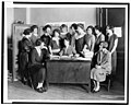 Margaret Sanger, half-length portrait, seated behind desk, surrounded by twelve other women) - Underwood & Underwood Studios, N.Y LCCN93504866.jpg