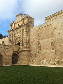 The 18th-century Mdina Gate and the walled-up medieval entrance Mdina Gate and Old Gate.jpeg