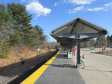 A curved railway station platform with a metal canopy