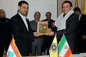 Two smiling men holding a golden plaque together